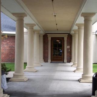 A grand entrance with rows of columns leading to a wooden door.