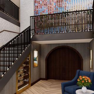 A modern lobby featuring a stylish staircase, colorful artwork, and elegant furniture.