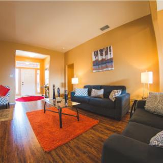 A cozy and modern living room featuring stylish sofas, a vibrant rug, and warm lighting.