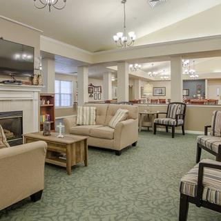A cozy and spacious living room with comfortable seating, a fireplace, and elegant lighting.
