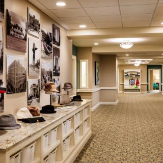 Stylish hallway with vintage photographs and hats on display.
