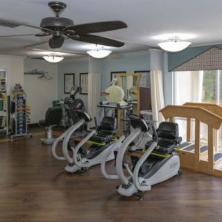 A well-lit fitness center featuring stationary bikes and various exercise equipment.