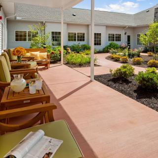 A peaceful patio area with comfortable seating, surrounded by a beautifully landscaped garden.