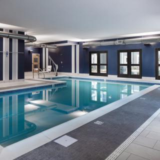 A modern indoor swimming pool with sleek design and large windows.