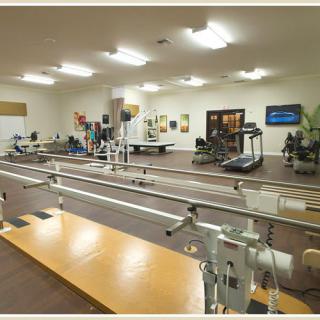 A spacious physical therapy clinic equipped with various rehabilitation and exercise machines.