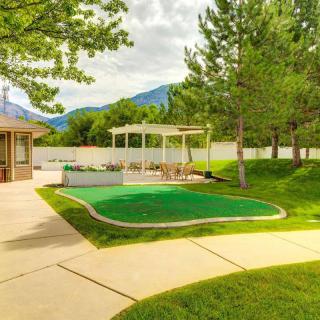 A serene backyard with lush greenery, a small pavilion, and a view of distant mountains.