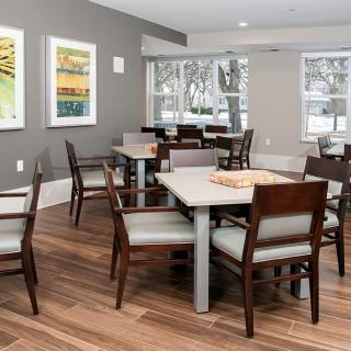 A modern dining area with wooden tables and chairs, adorned with artwork on the walls.