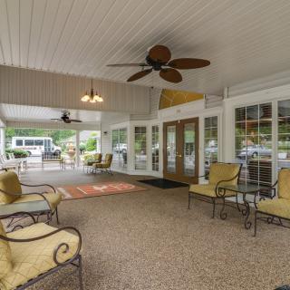 A spacious covered patio with comfortable seating and ceiling fans.
