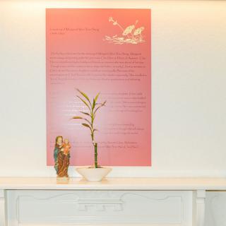 A display featuring a potted plant and a colorful sign with text.