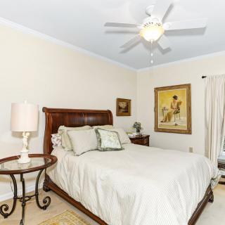 A cozy bedroom with a wooden bed, decorative pillows, and framed artwork on the walls.