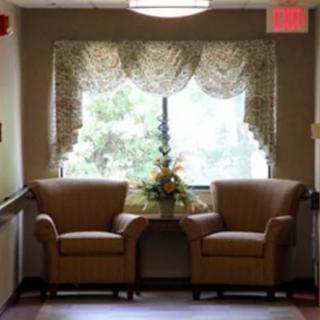 Cozy seating area with two armchairs by a window in a sunlit room.