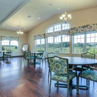 A spacious dining room with elegant decor, featuring large windows and ample natural light.