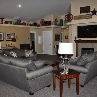 A cozy living room featuring comfortable sofas, a stylish lamp, and a warm fireplace.
