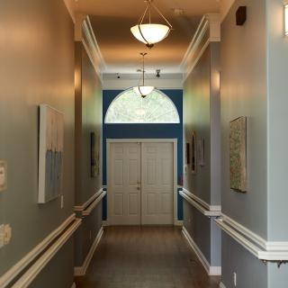 A well-lit hallway with closed double doors at the end.
