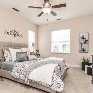 A modern and spacious bedroom featuring elegant decor in neutral tones.
