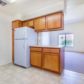 A small kitchen area with wooden cabinets and a white refrigerator.
