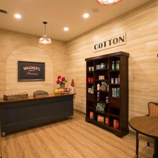 A cozy reception area with a desk, bookshelf, and warm lighting.