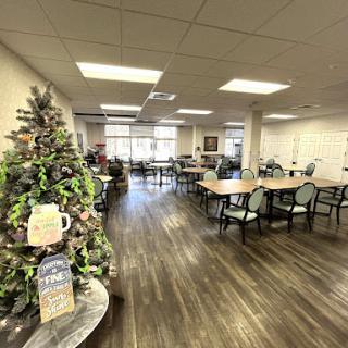 A spacious dining area featuring a beautifully decorated Christmas tree, ready for gatherings.