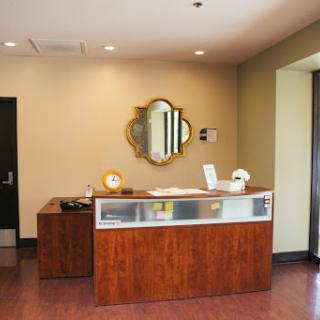 A view of a stylish reception area featuring a wooden desk and decorative mirror.