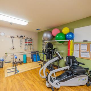 A well-equipped rehabilitation gym featuring various exercise equipment, balance balls, and weights for physical therapy and fitness training.