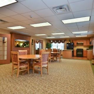 Spacious dining and kitchen area with wooden furniture and bright lighting.