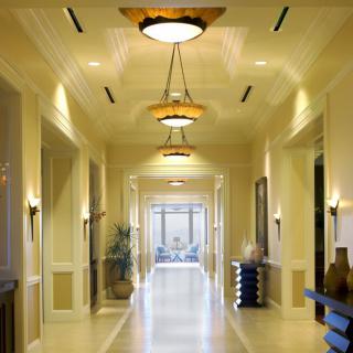 A modern hallway with elegant ceiling lights and warm decor.