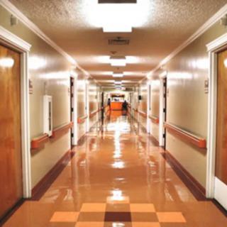 A brightly lit hospital hallway with doors on both sides.