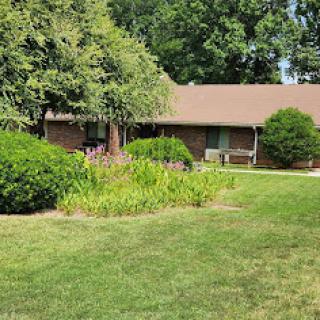 A charming home surrounded by lush greenery and well-kept gardens.