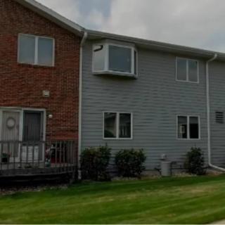 A suburban townhouse with a brick and siding exterior.