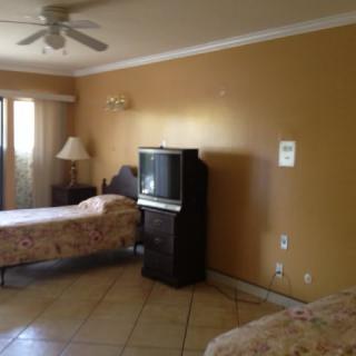 A hotel room with two beds, a television, and basic furnishings.