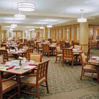 An empty dining room with neatly arranged tables and chairs.