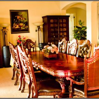 A beautifully decorated dining room featuring an ornate wooden table surrounded by matching chairs.