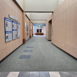 A spacious hallway with a well-lit pathway leading to an open area.