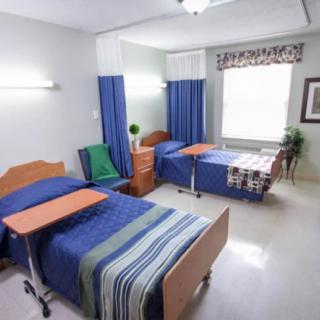 A clean and organized hospital room with two patient beds.