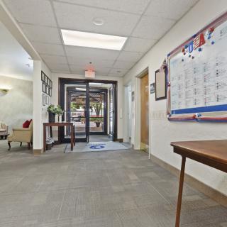 A spacious office hallway with an entrance door and a wall-mounted calendar.