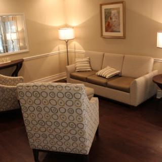 A cozy living room setup featuring a comfortable couch and stylish armchairs, illuminated by warm lamps.