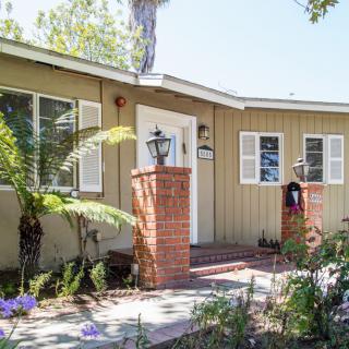 A charming residential house with a neatly landscaped front yard.