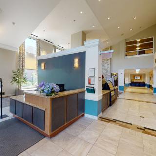 A modern hotel lobby with a reception desk and spacious interior.