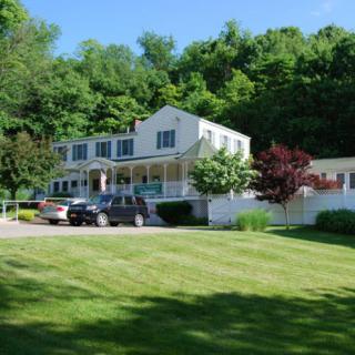 A picturesque house surrounded by lush greenery and a spacious lawn.