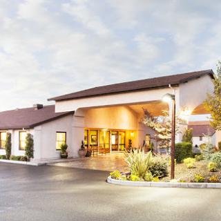 A welcoming hotel entrance showcasing modern architectural design and well-maintained landscaping.