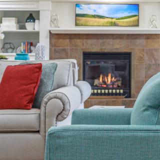 A cozy living room featuring a fireplace, colorful cushions, and stylish home decor.