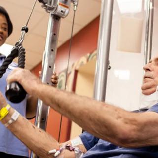 A patient undergoing physical therapy with a healthcare professional supervising.
