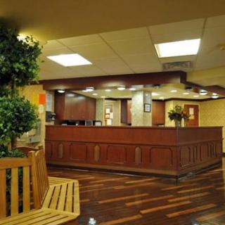 A welcoming hotel lobby with wooden furnishings and warm lighting.