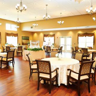 A spacious and elegantly designed dining area with beautifully arranged tables and chairs, perfect for gatherings.
