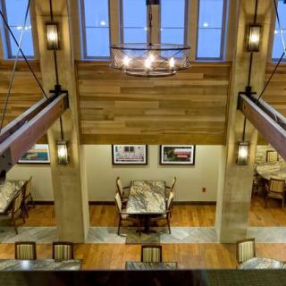 A modern dining area with a wooden ceiling and contemporary lighting.