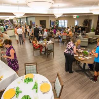 A social gathering with people enjoying food and conversation indoors.