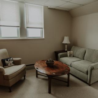 A cozy minimalist living room with a sofa, armchair, and coffee table.