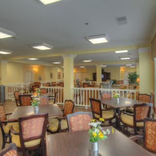 Spacious dining area with multiple tables and chairs, decorated with flowers.