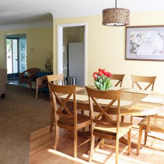 A bright and cozy dining room with a wooden table, chairs, and decorative elements.