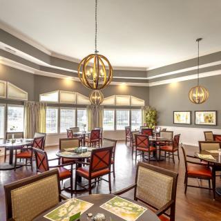 A spacious and well-lit restaurant dining area with neatly arranged tables and chairs.